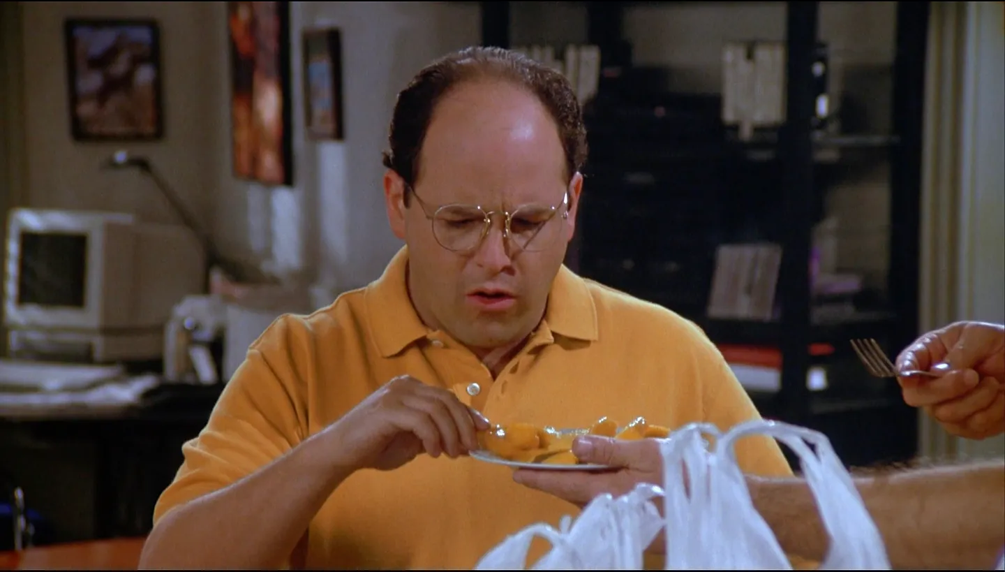 George Costanza eating mango from a plate.