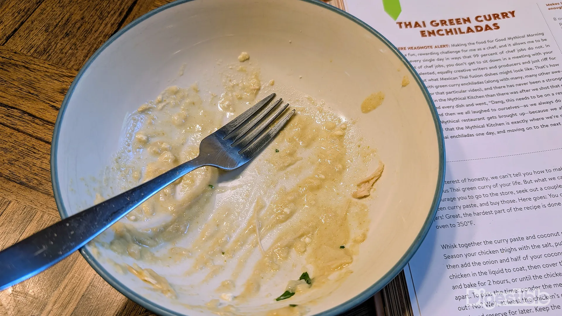 An empty bowl next to a cookbook.