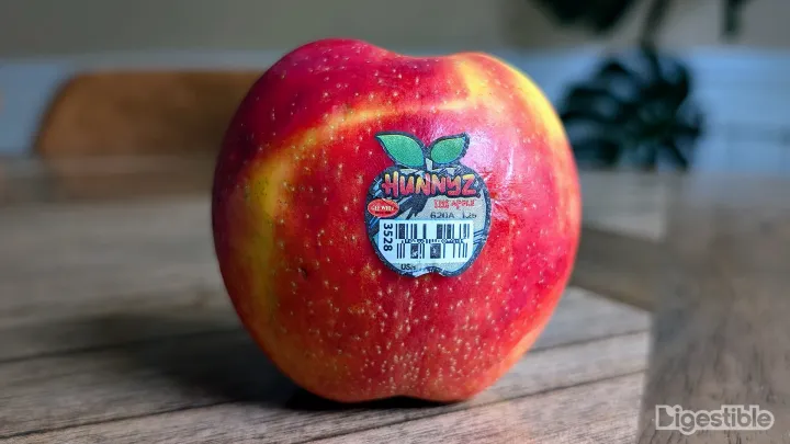 A red and yellow apple on a table.